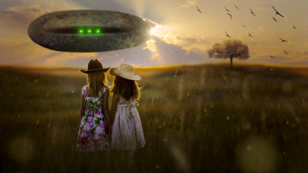 Rückseitig Ansicht zweier an den Händen haltender Mädchen auf einer Wiese und im Hintergrund ein riesiges außerirdisches Raumschiff schwebend.