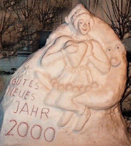 Schneeskulptur Mondfrau Luna - Frau mit großem Herz auf der Mondsichel sitzend und Neujahrswünsche für das Jahr 2000.