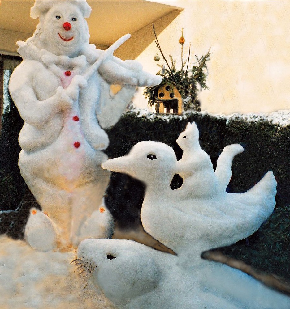 Schneefiguren - Geigespielender Clown und im Fordergrund, aufeinanderstehend Robbe, Ente und Eichhörnchen.